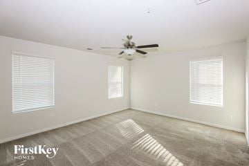 Concord house for rent - a spacious living room with carpet and a ceiling fan