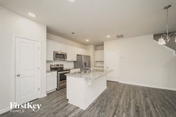 Concord house for rent - a renovated kitchen with white cabinets and a marble counter top