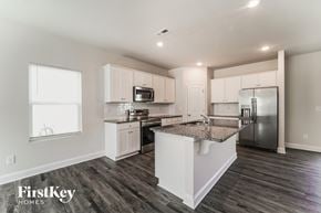 Charlotte house for rent - a white kitchen with stainless steel appliances and a granite counter top
