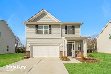 Charlotte house for rent - a beige house with a white garage door