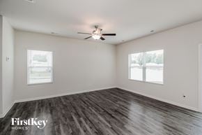 Charlotte house for rent - A spacious room with a ceiling fan and two windows.