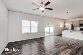 Charlotte house for rent - A spacious room with a ceiling fan and wooden flooring.