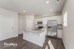 Charlotte house for rent - a white kitchen with a marble counter top and stainless steel refrigerator