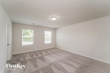 Charlotte house for rent - a spacious living room with carpet and two windows