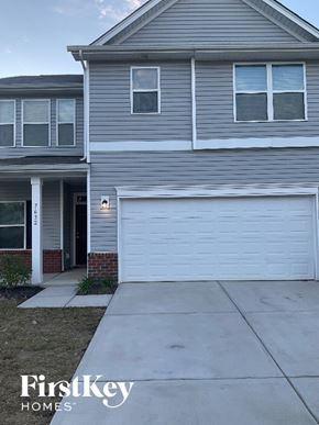 Charlotte house for rent - A grey house with a white garage door in front.