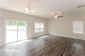 Charlotte house for rent - a living room with wood floors and a ceiling fan