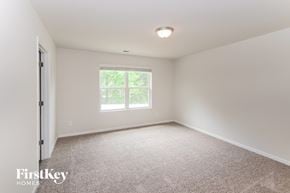 Charlotte house for rent - a bedroom with a large window and a carpeted floor
