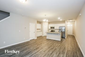 Concord house for rent - a kitchen and living room with a wood floor and white cabinets