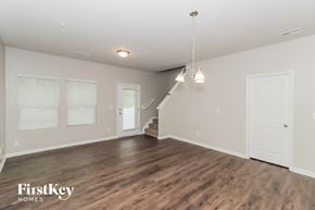 Concord house for rent - A spacious room with wooden floors and a staircase leading to another level.