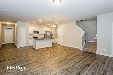 Concord house for rent - A spacious kitchen and living room with wooden flooring and white walls.