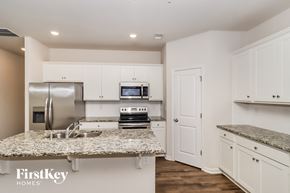 Concord house for rent - a kitchen with white cabinets and granite counter tops and a sink