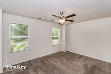 Concord house for rent - a living room with carpet and a ceiling fan