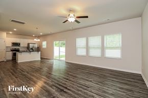 Charlotte house for rent - A spacious room with a ceiling fan and wooden flooring.