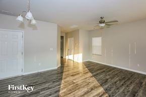 Charlotte house for rent - A spacious room with wooden flooring and a ceiling fan.