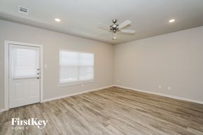 Lewisville house for rent - A room with a ceiling fan and wooden flooring.