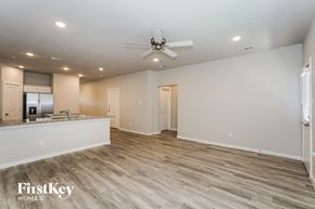 Lewisville house for rent - A spacious room with a fan and light wood flooring.