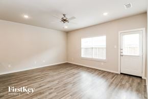 Lewisville house for rent - the spacious living room with wood flooring and a ceiling fan