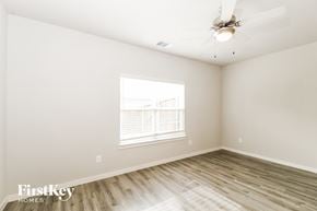 Lewisville house for rent - a bedroom with white walls and wood floors and a ceiling fan