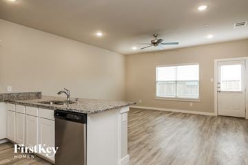 Lewisville house for rent - a kitchen with a counter top and a sink and a ceiling fan