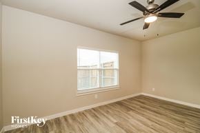 Lewisville house for rent - a bedroom with a ceiling fan and a window