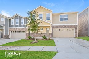 Lewisville house for rent - a beige house with two garage doors and a lawn