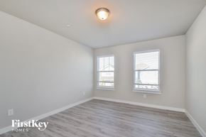Lewisville house for rent - the living room of an apartment with wood flooring and two windows