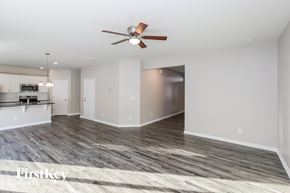 Charlotte house for rent - A spacious room with a ceiling fan and a wooden floor.