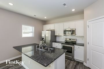 Charlotte house for rent - A kitchen with a black countertop and white cabinets.