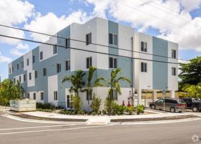Miami apartment for rent - a white and blue building with cars parked in front of it