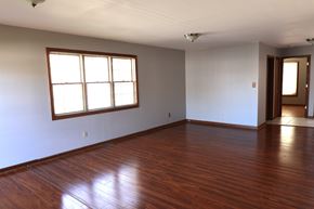 Merrillville house for rent - an empty living room with wood floors and a window