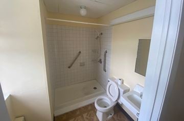 Scranton apartment for rent - A white toilet is in a small bathroom with a white tub and a white sink.