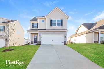 Greenville house for rent - a white house with a white garage door and a driveway