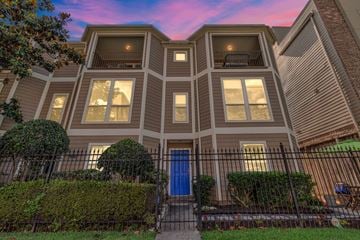 Houston apartment for rent - A house with a blue door and a black fence.