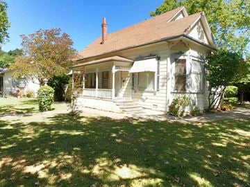 Davis house for rent - a small white house with a porch and a lawn