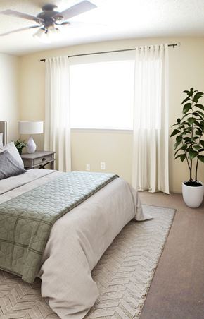 Amarillo apartment for rent - A bedroom with a large bed and a ceiling fan.