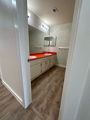 El Campo apartment for rent - A bathroom with a red countertop and white cabinets.