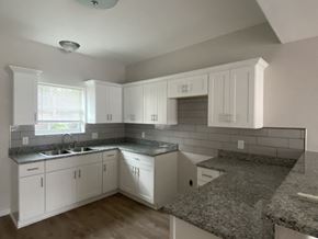 El Campo apartment for rent - an empty kitchen with white cabinets and granite counter tops