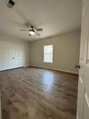 El Campo apartment for rent - an empty living room with a ceiling fan and wood floors