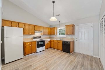 Jacksonville house for rent - A kitchen with wooden cabinets and a white refrigerator.