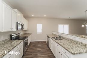 Charlotte house for rent - a large kitchen with white cabinets and granite counter tops