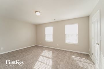 Charlotte house for rent - a spacious living room with carpet and two windows