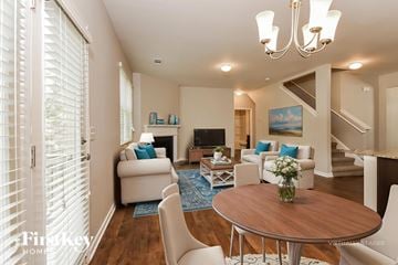 Dallas house for rent - A living room with a wooden table and white chairs.