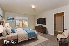 Dallas house for rent - A bedroom with a bed, a chair, and a television.