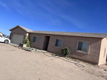 Buckeye house for rent - a brown house with a hose on the ground
