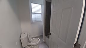 Orlando apartment for rent - A white toilet in a small bathroom with a door to the right.