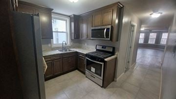 Orlando apartment for rent - A kitchen with a black refrigerator, a black stove, and a black microwave.