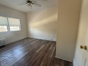 Cranford apartment for rent - A room with a ceiling fan and wood flooring.