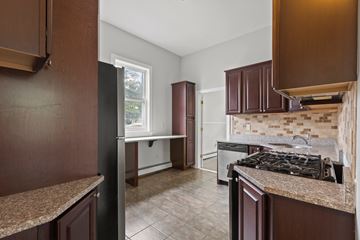 Plainfield apartment for rent - A kitchen with brown cabinets and a tiled floor.