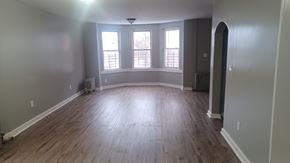 Newark apartment for rent - A room with wooden floors and a large window.