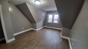 Newark apartment for rent - A room with wooden floors and a window with blinds.